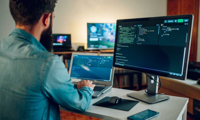 Back view of a senior developer typing code and programming a new generation of AI bots and AI generators at the home office. Artificial intelligence development and programming AI bots.