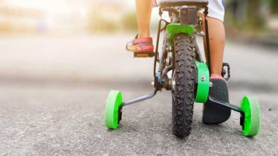 shutterstock 1175637019 learning to ride a bike training wheels