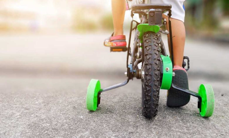 shutterstock 1175637019 learning to ride a bike training wheels