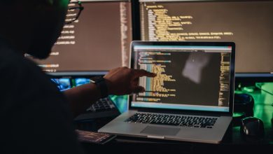 Man pointing at screen trying to see a part of his large code base.