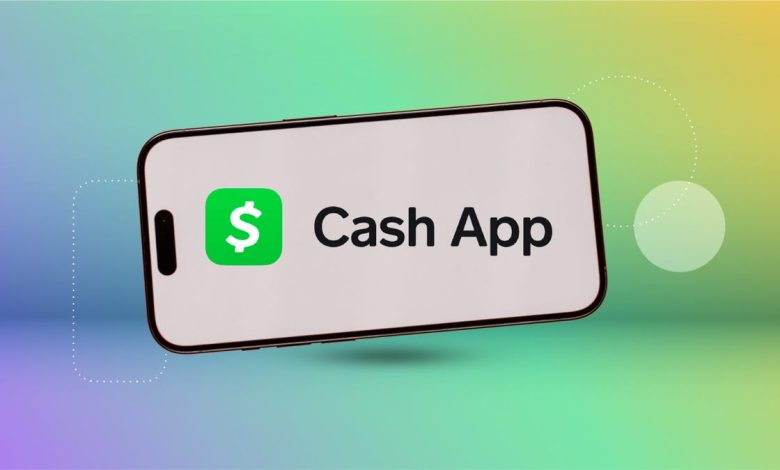 the Cash App logo on a smart phone in front of a blue, green and yellow multihued background