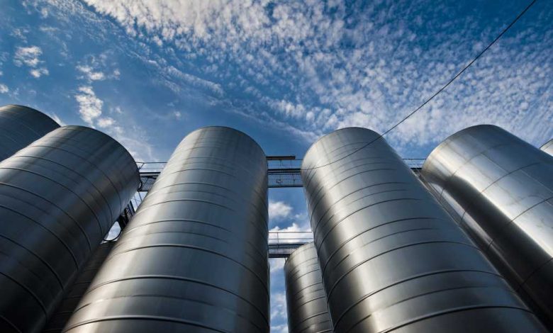 shutterstock 289153913 upward view of silver silos against a blue sky with clouds