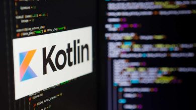 A computer screen shows the Kotlin logo against a backdrop of code.