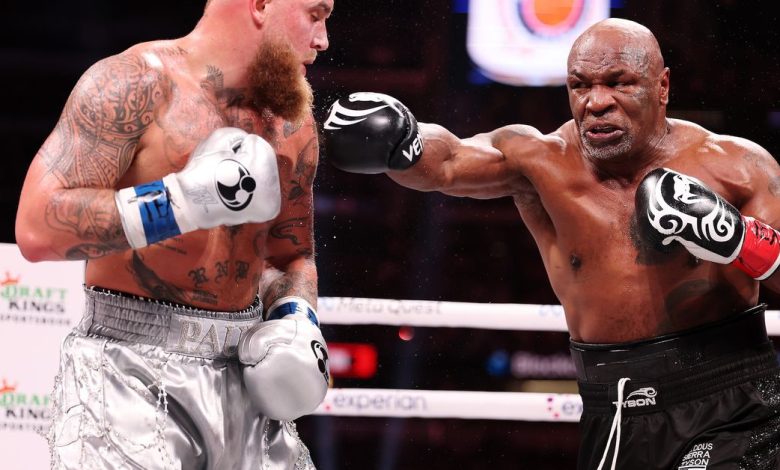 Image showing Mike Tyson, mid-punch as Jake Paul dodges.