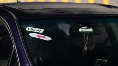 Uber and Lyft logos displayed in a car's windshield.