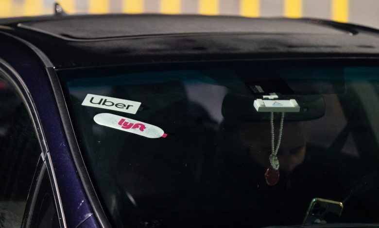 Uber and Lyft logos displayed in a car's windshield.