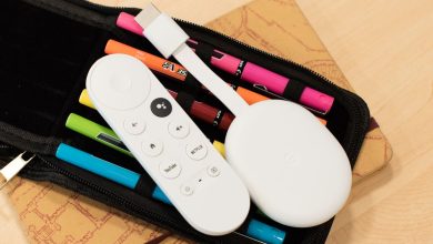 The Chromecast with Google TV (4K) with its remote lying on a pack of pens.