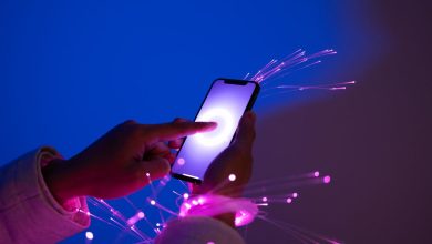 Person holding a smartphone with futuristic neon background