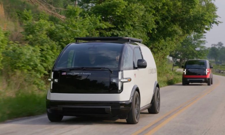 Two Canoo EVs drive on a road in Bentonville, Arkansas.