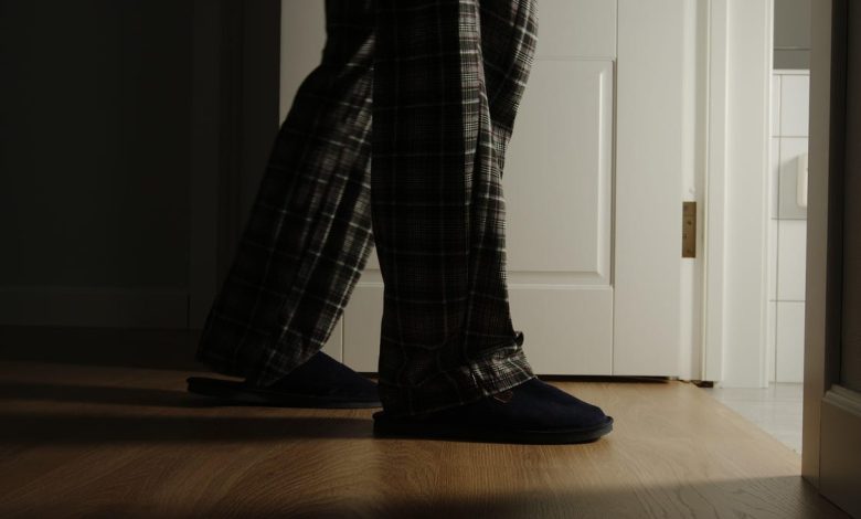 Man in pajamas and slippers walking to the bathroom during the night