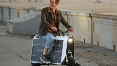 A rider sitting on the Lightfoot scooter propped up with one foot.