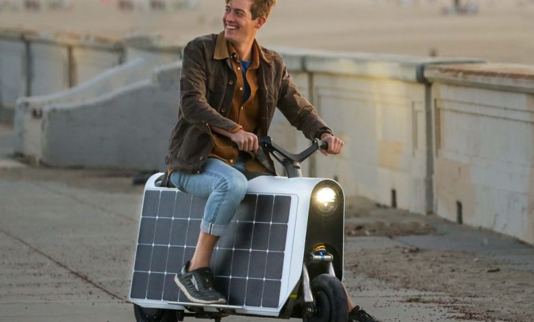 A rider sitting on the Lightfoot scooter propped up with one foot.