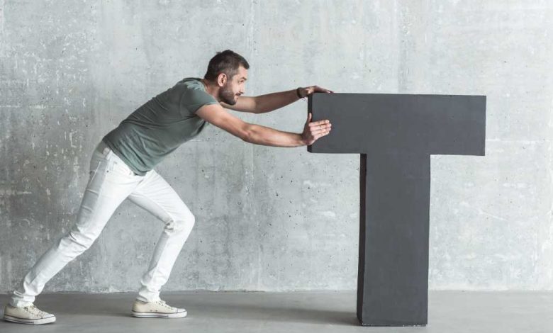 A young man pushes the letter t to the center of the screen.