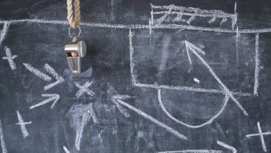 Tactical diagram of soccer plays in white chalk on a blackboard.