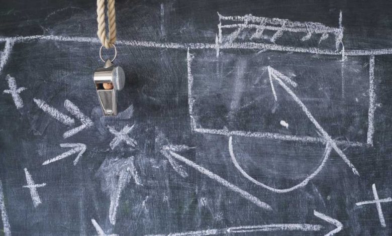 Tactical diagram of soccer plays in white chalk on a blackboard.