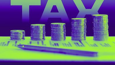 Coins piled up like a bar chart on top of tax documents with the word TAX in background.